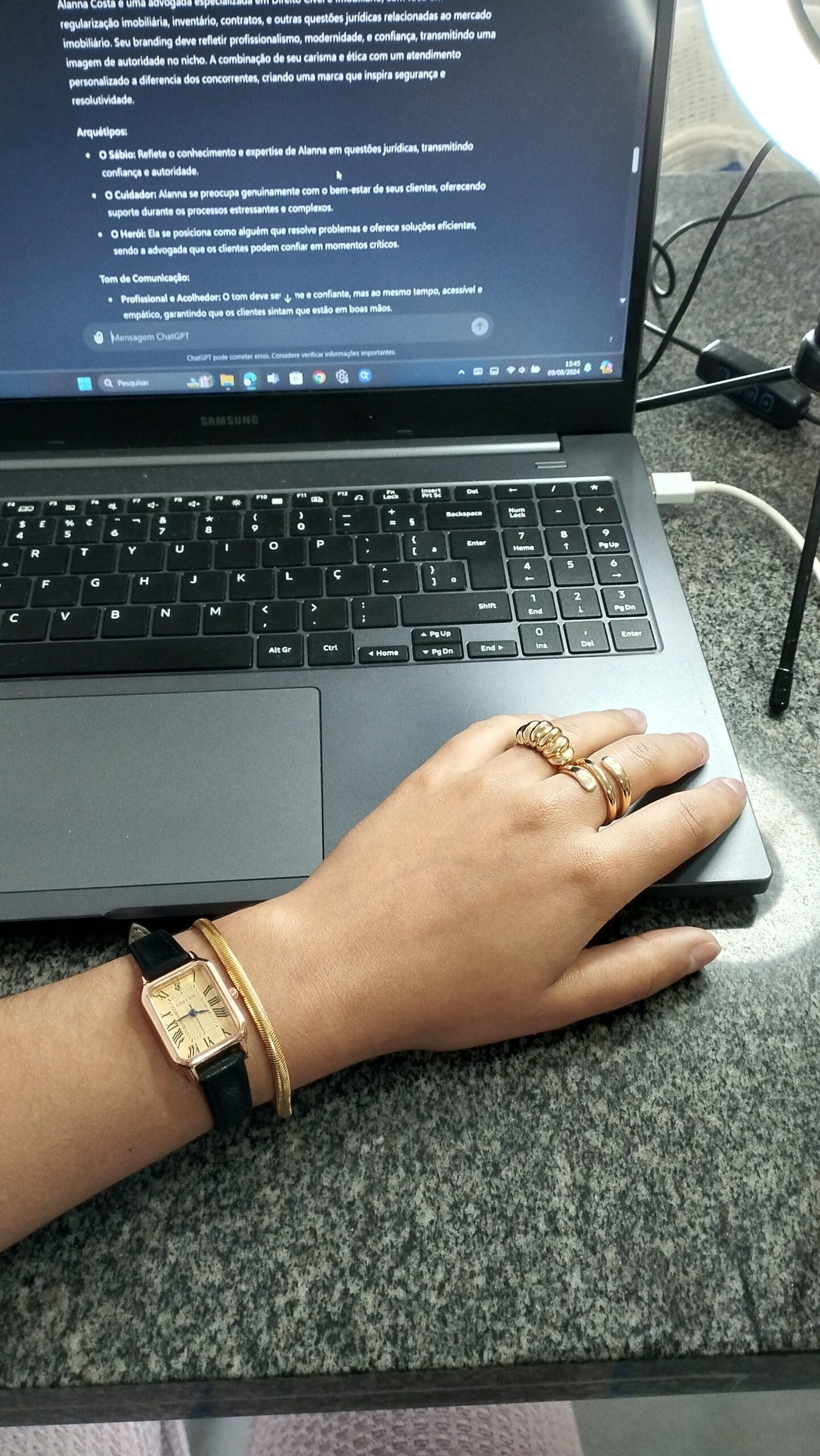 A hand with gold jewelry rests on a laptop keyboard, with a business document open on the screen, symbolizing automated lead generation, business strategy, and digital marketing.